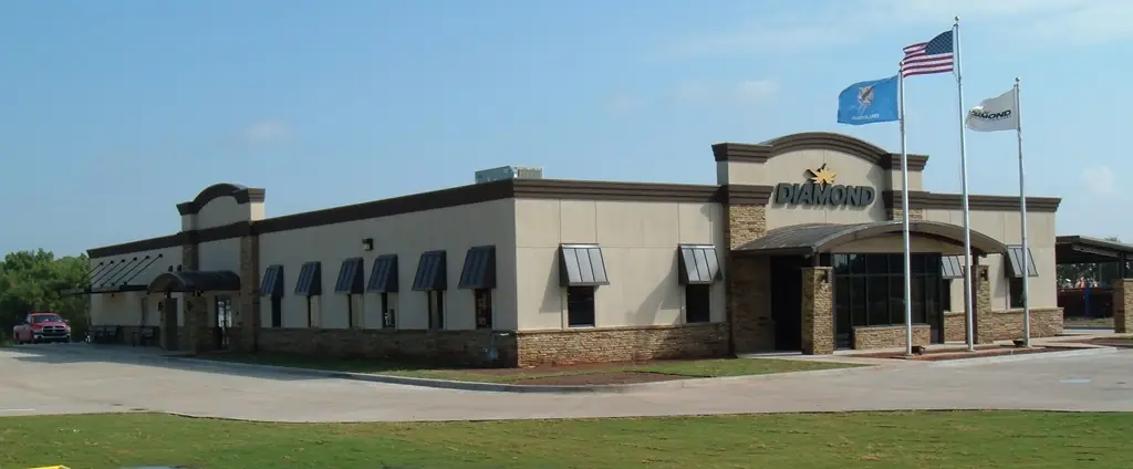 Diamond Services office building in Woodward, Oklahoma, tan stucco and stone with flagpoles