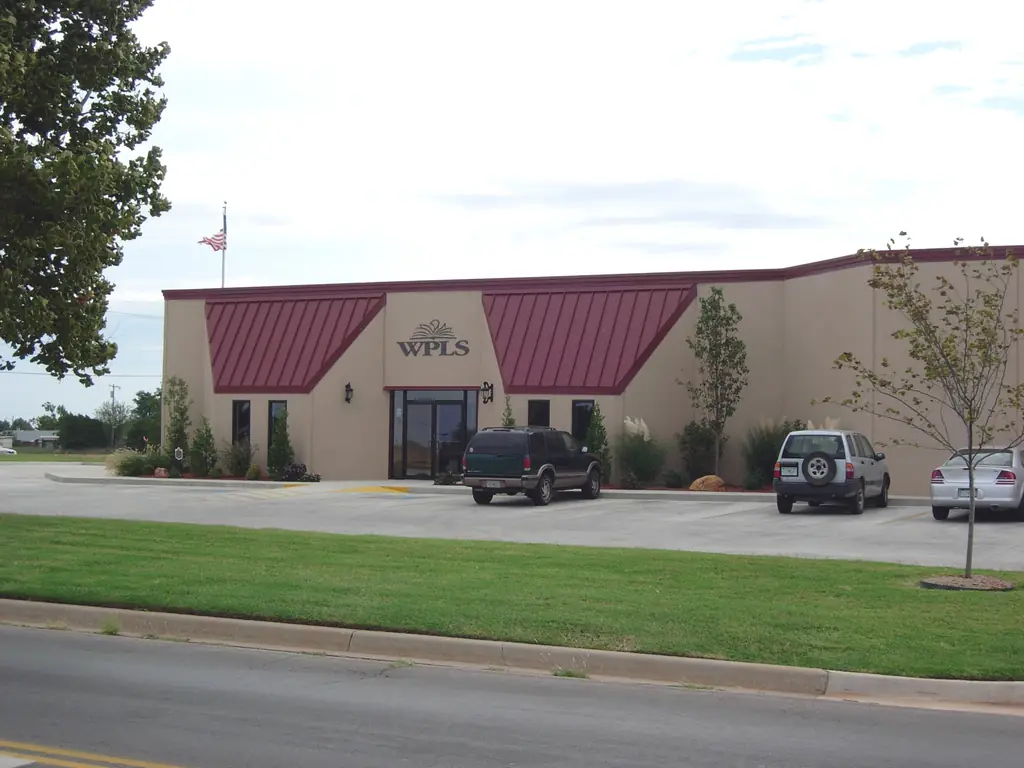 Western Plains Library System building in Clinton, Oklahoma, tan stucco with burgundy awnings